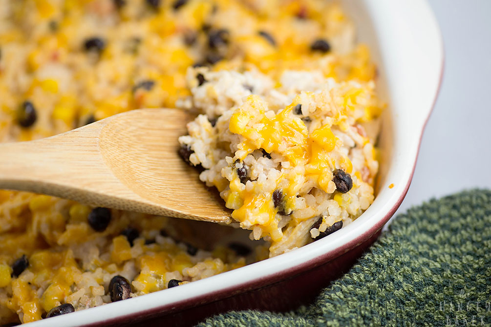 Cheesy Rice, Chicken and Bean Bake - An easy meal packed with flavors! Moist chicken, salsa, gooey cheese, beans and tender rice will please any family!